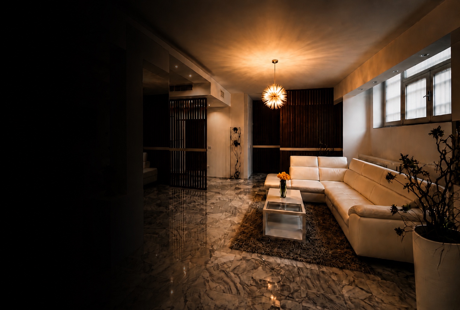 Boutique residence living room in Milan with warm chandelier glow, marble reflections, walnut dividers and white sofa