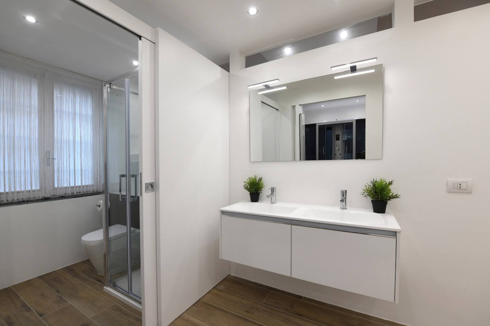 Double sink vanity with warm lighting in the private wellness area at La Galleria Milano