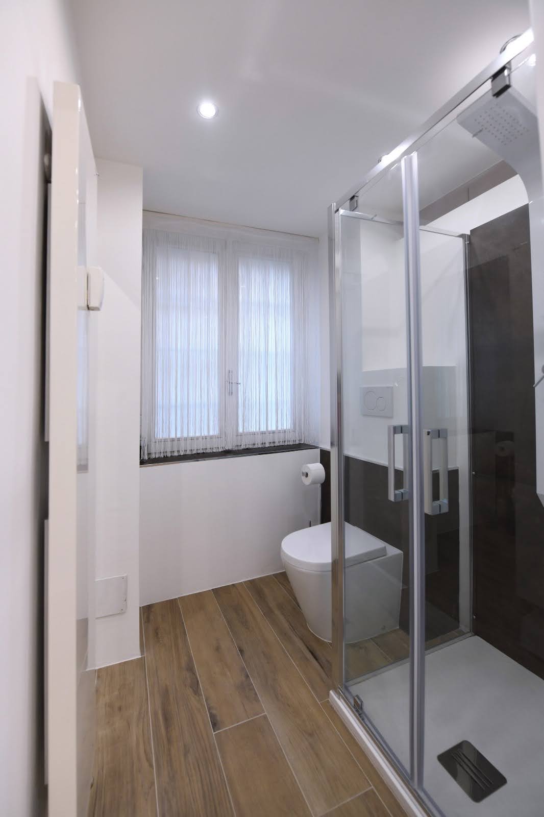 Steam shower detail in a private wellness bathroom with window light and warm wood flooring